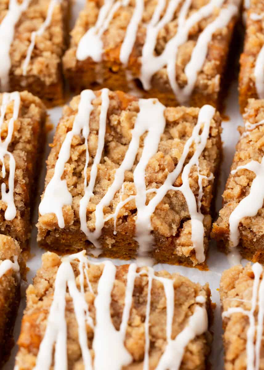 Sliced pumpkin coffee cake with glaze on top.