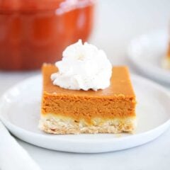 Pumpkin pie bar with shortbread crust on a white plate.