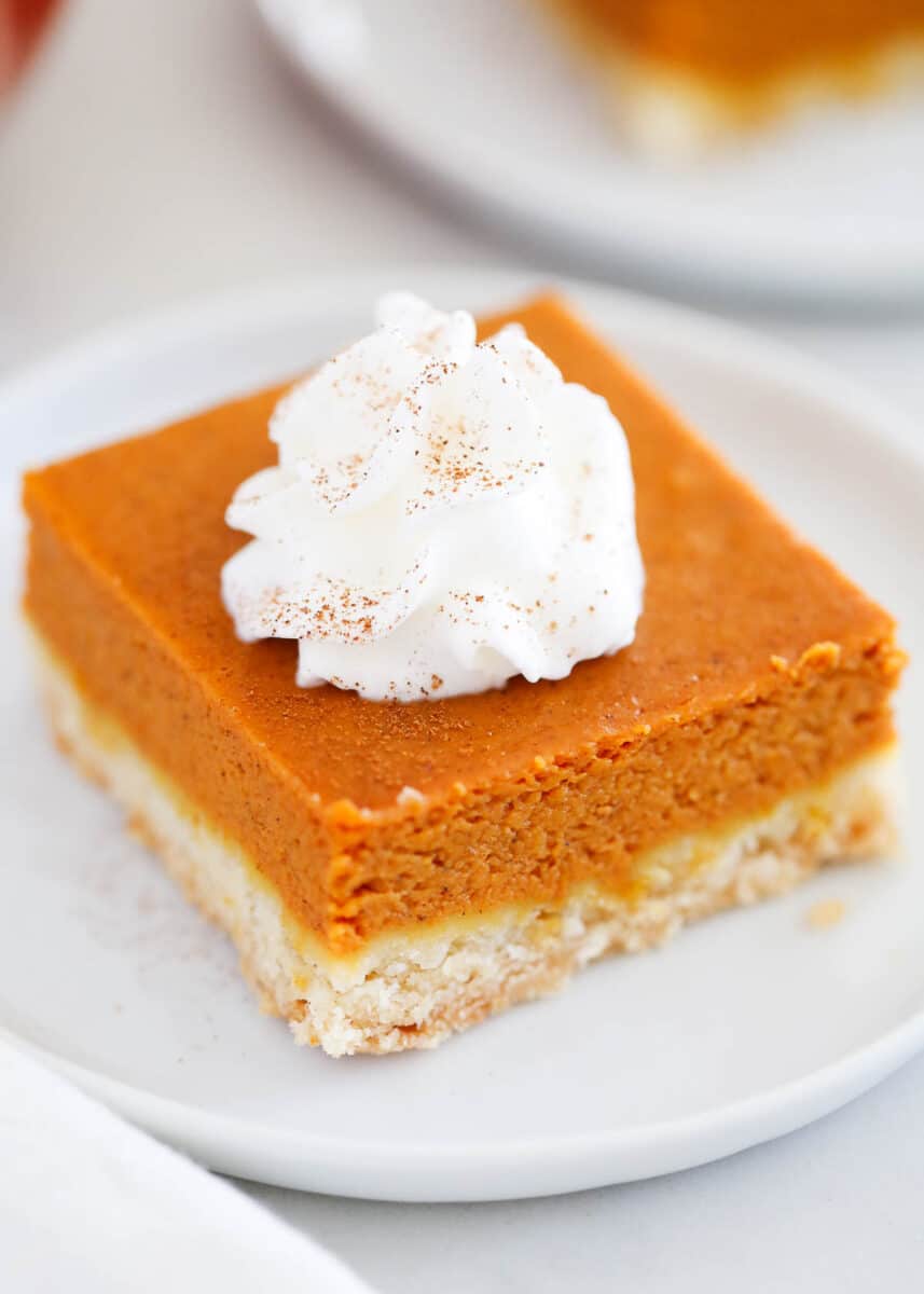 Pumpkin pie bar with whipped cream on top.