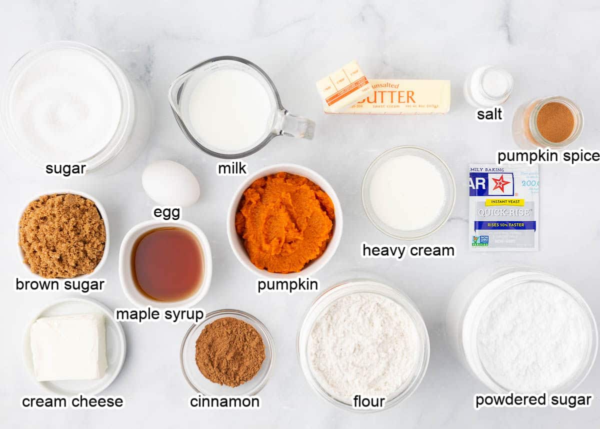 Pumpkin cinnamon roll ingredients on a marble counter.