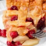 Slice of apple cranberry pie on a plate.