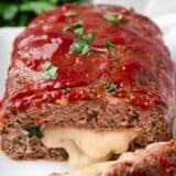 Sliced stuffed meatloaf on plate.