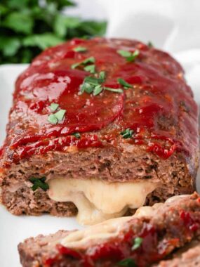 Sliced stuffed meatloaf on plate.