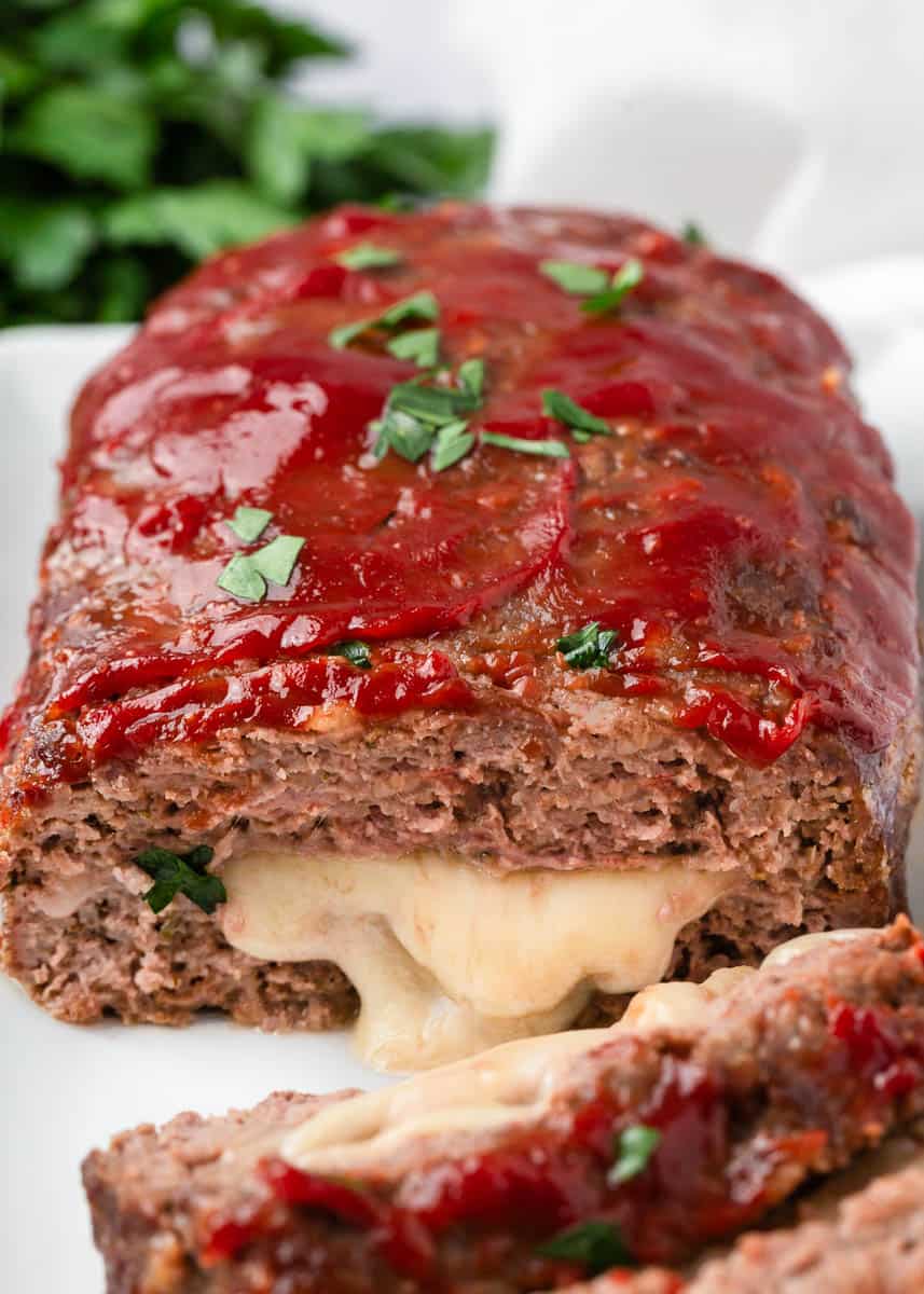 Sliced stuffed meatloaf on plate.