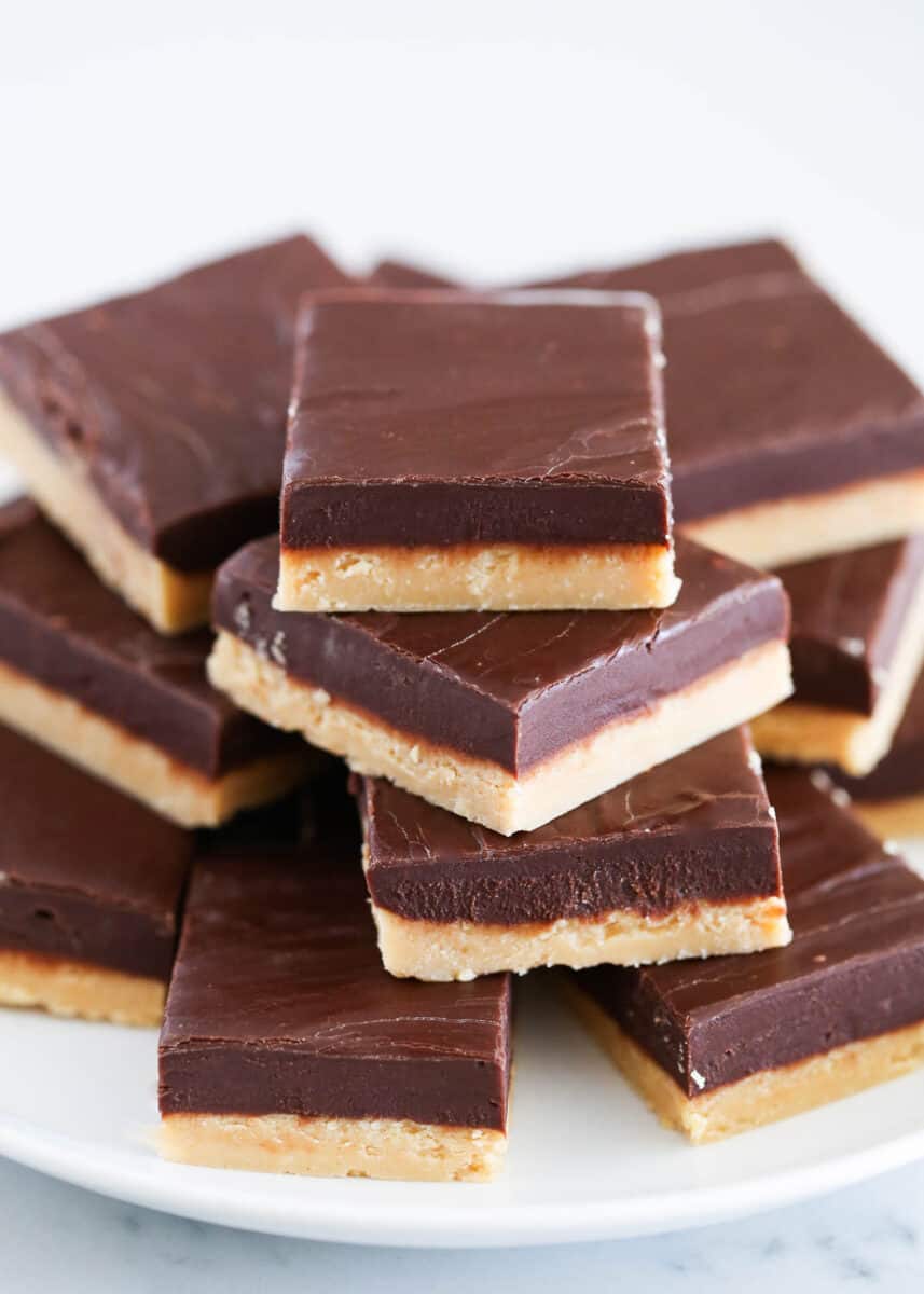 Stack of chocolate peanut butter fudge on a white plate.