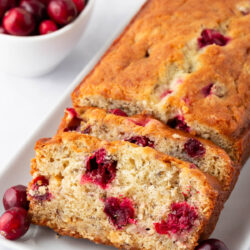 Sliced cranberry banana bread on a white plate.