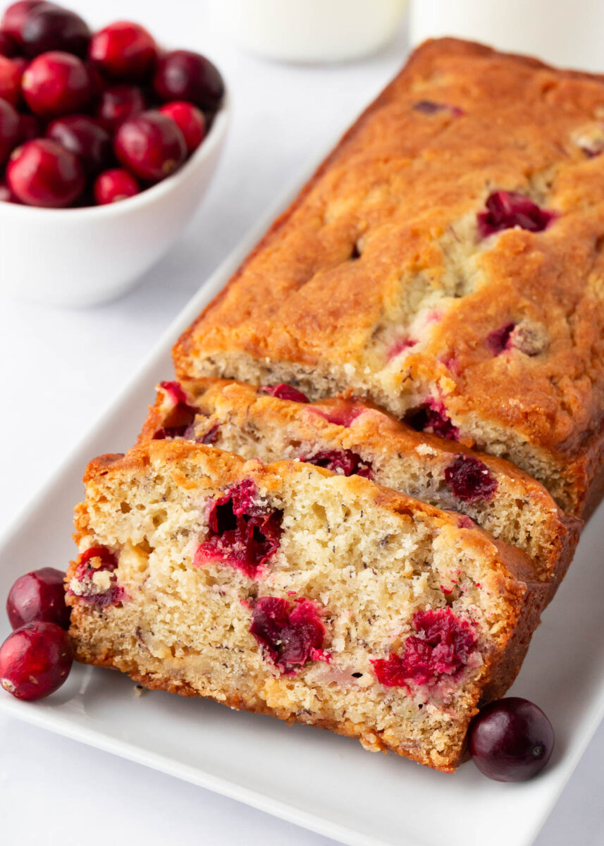 Sliced cranberry banana bread on a white plate.