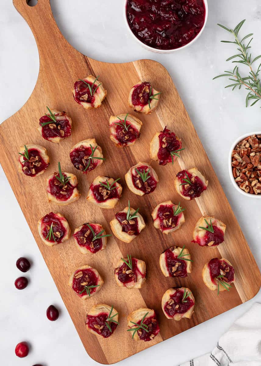 Cranberry brie bites on a wooden platter.