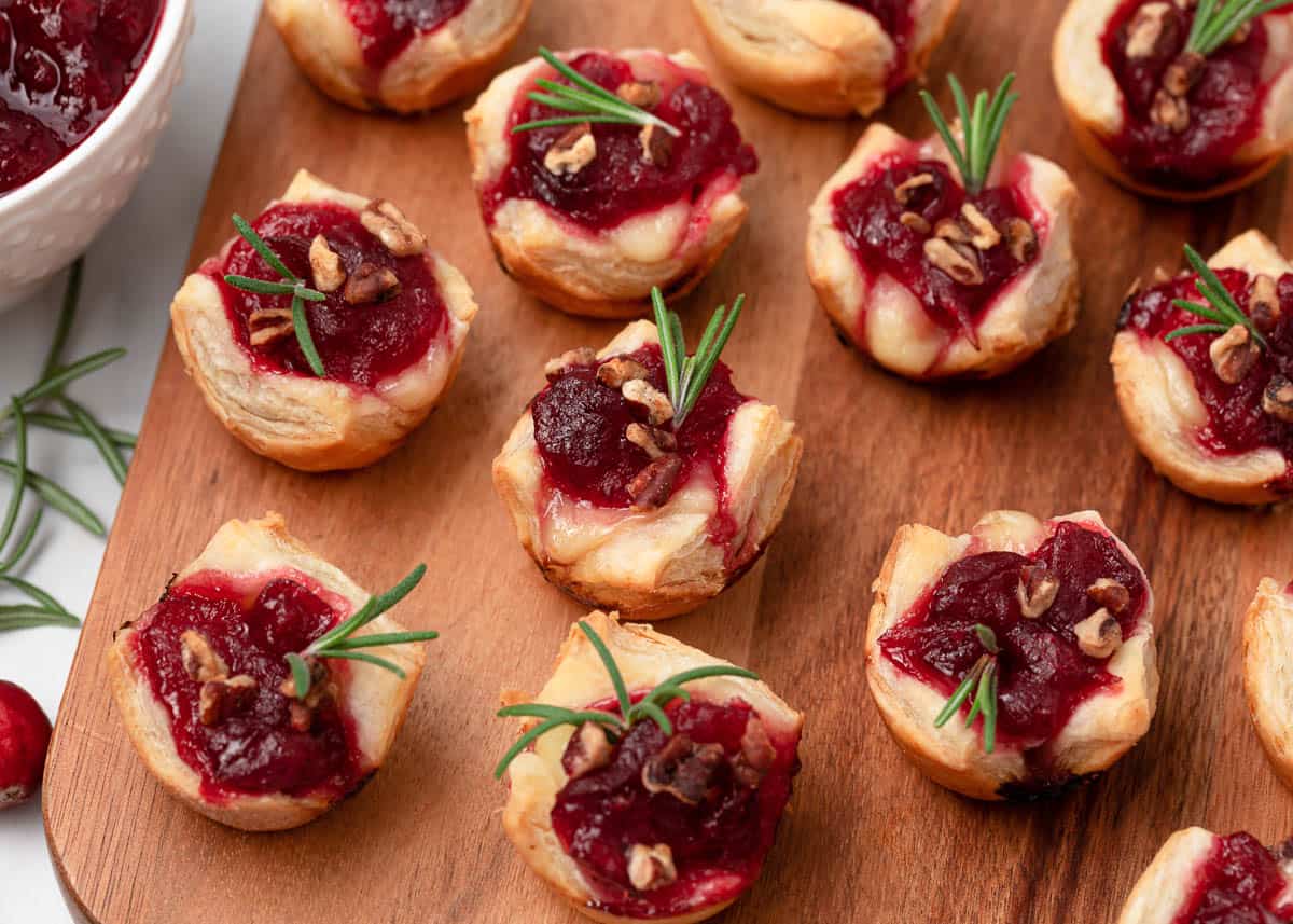 Cranberry brie bites on wooden board.