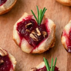 Cranberry brie bites on a wooden board.