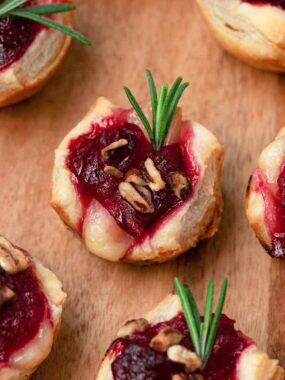 Cranberry brie bites on a wooden board.
