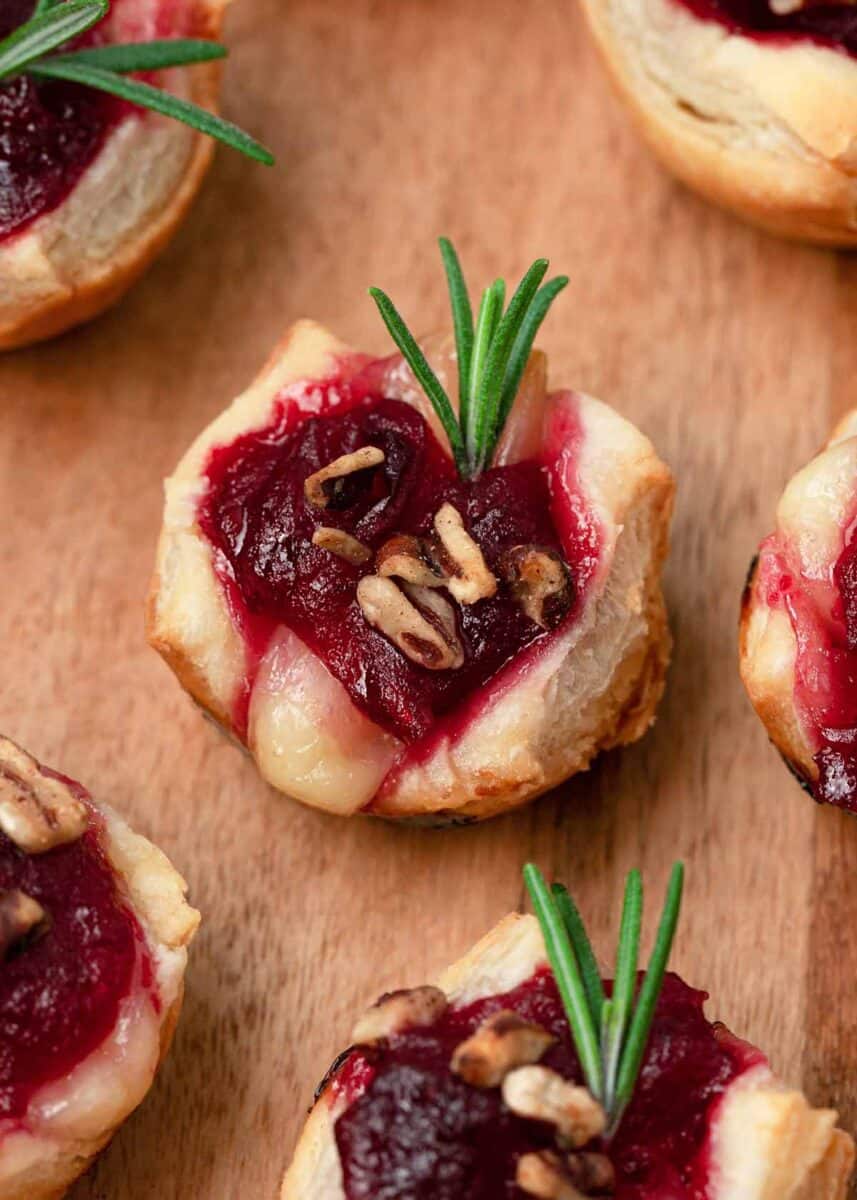 Cranberry brie bites on a wooden board.