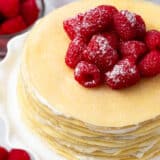 Crepe cake with raspberries on top.