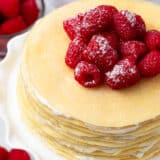 Crepe cake with raspberries on top.