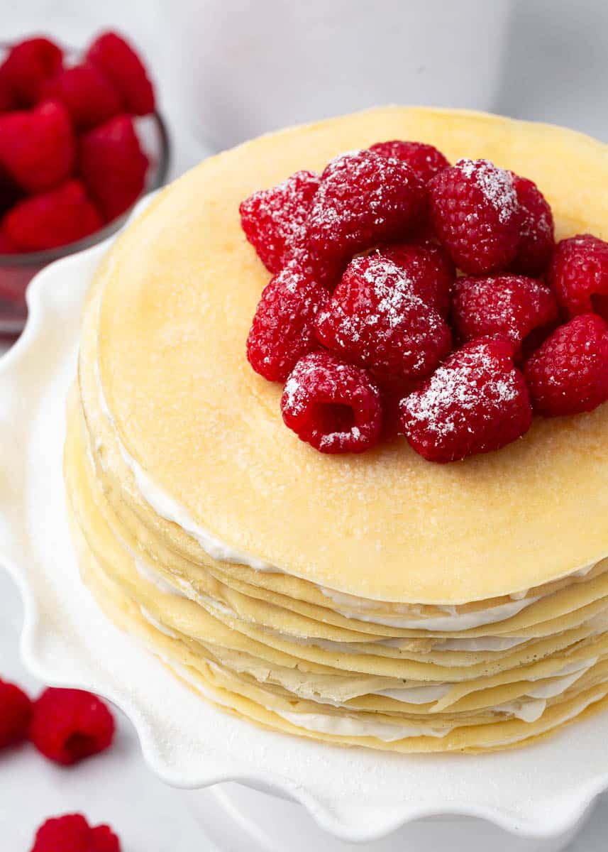 Crepe cake with raspberries on top.