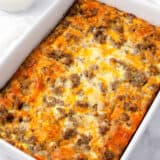 Sausage crescent roll breakfast casserole baked in white baking dish.