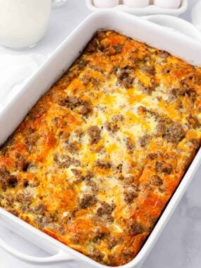 Sausage crescent roll breakfast casserole baked in white baking dish.