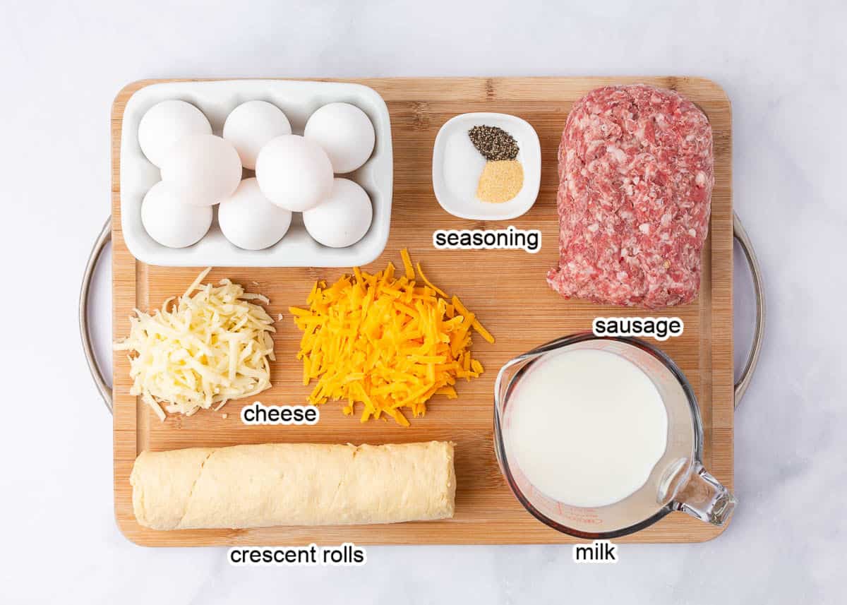 Crescent Roll Breakfast Casserole ingredients on wooden board.