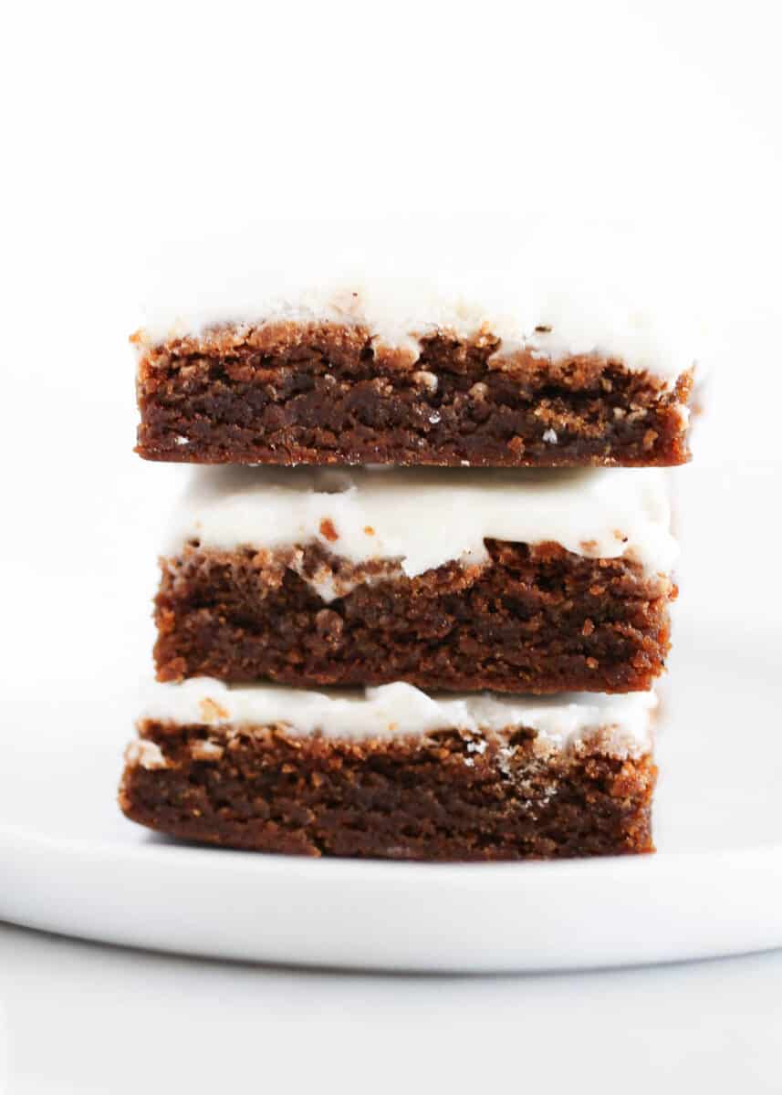 Stack of gingerbread bars on white plate.