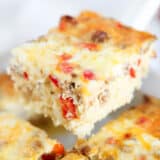 Slice of hashbrown breakfast casserole in a white baking dish.