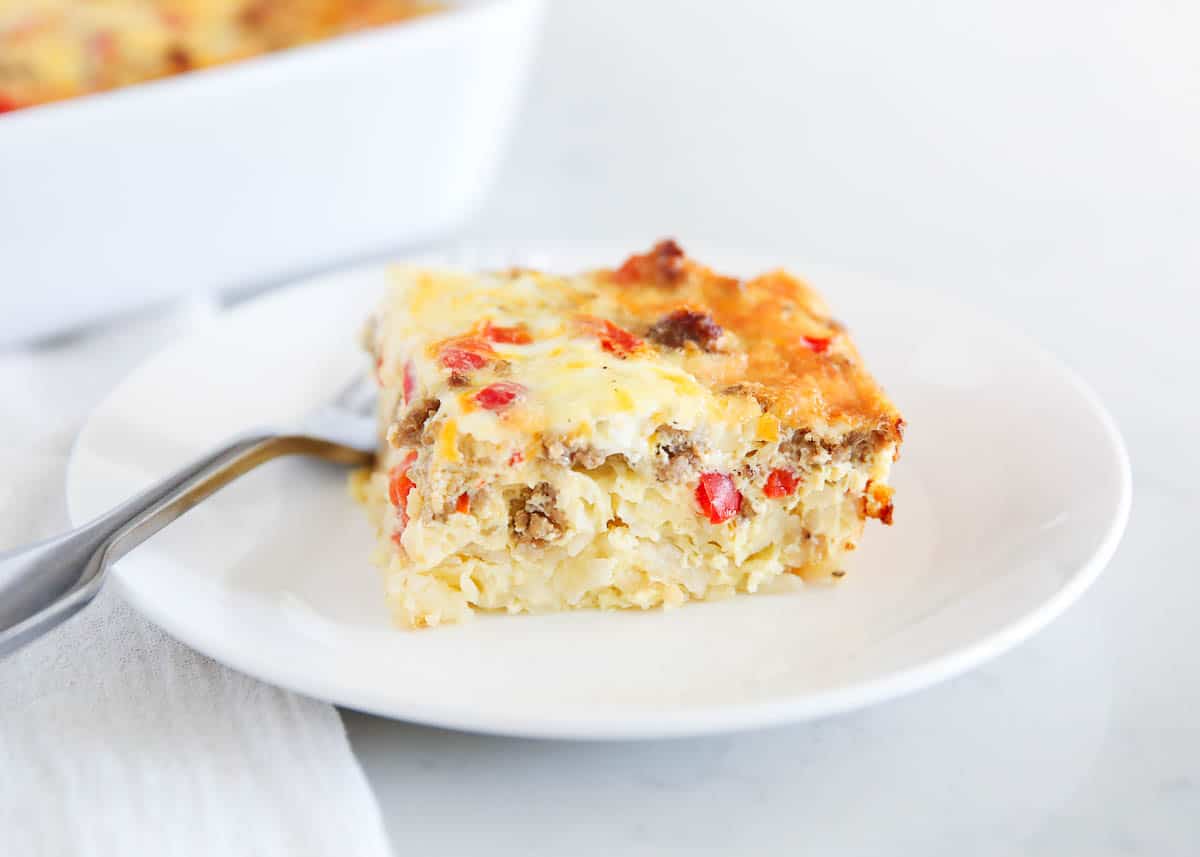 Slice of hashbrown breakfast casserole on a white plate.