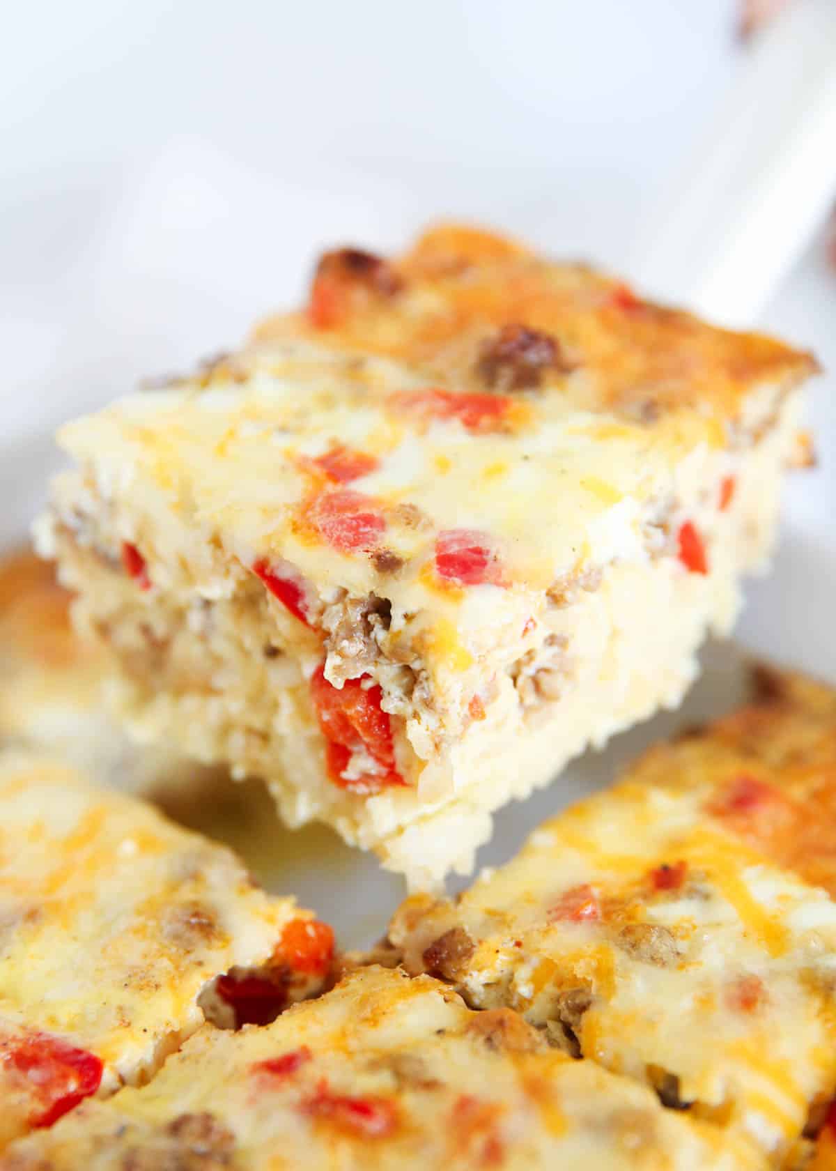 Slice of hashbrown breakfast casserole in a white baking dish.