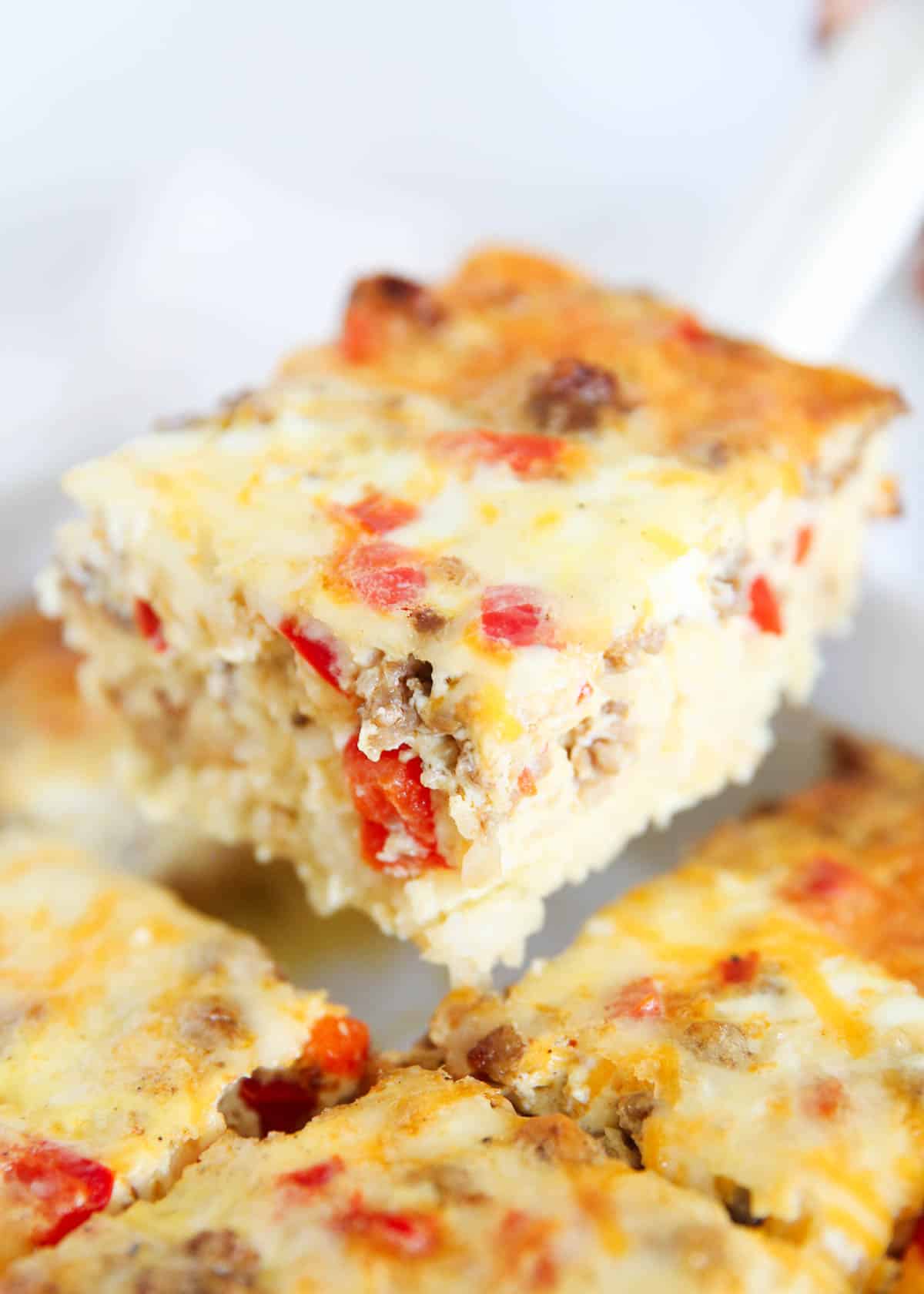 Slice of hashbrown breakfast casserole in a white baking dish.