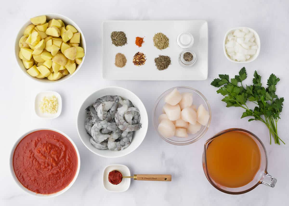 Seafood stew ingredients on counter.