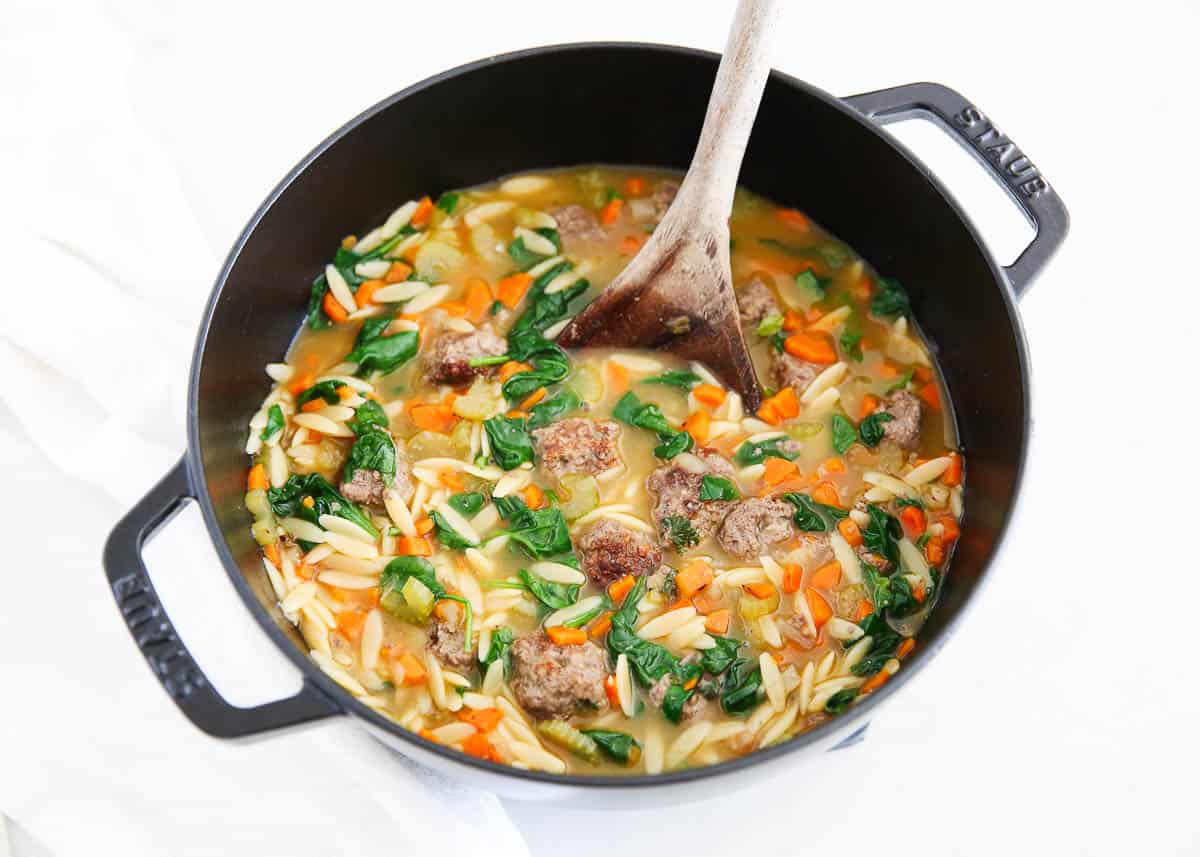 Italian Wedding soup cooked in a black pot.