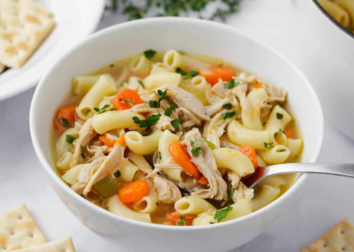 Turkey noodle soup in a white bowl.