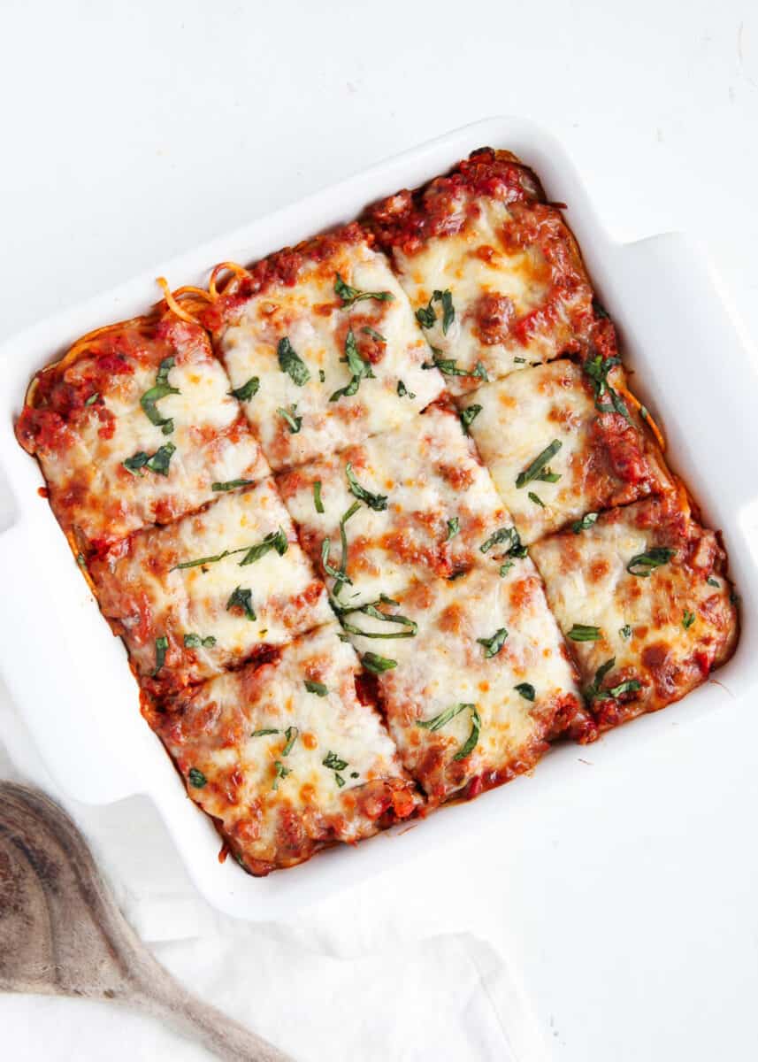 Million dollar spaghetti casserole in white baking dish on counter.