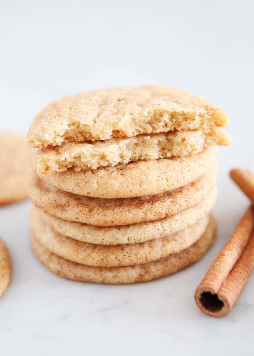 Stack of snickerdoodle cookies with cinnamon sticks.