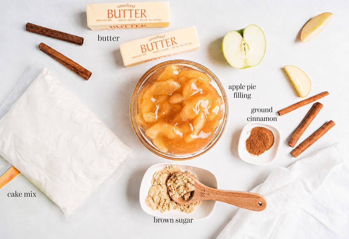 This easy apple dump cake takes 5 minutes to prep with just 5 simple ingredients. It's the perfect pantry dessert for fall that can be made in either the oven or crockpot. Apple dump cake ingredients including apple pie filling, butter, cake mix and cinnamon.