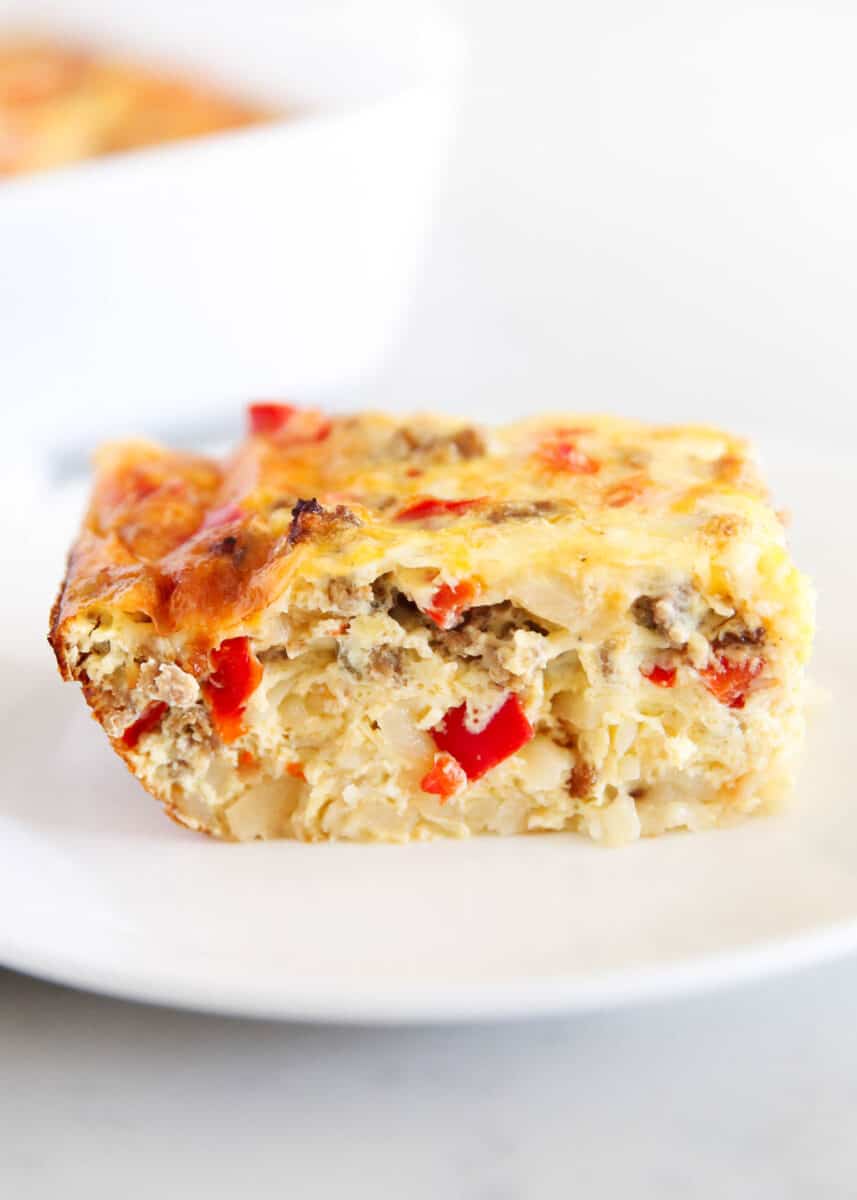 Slice of hashbrown breakfast casserole on white plate.