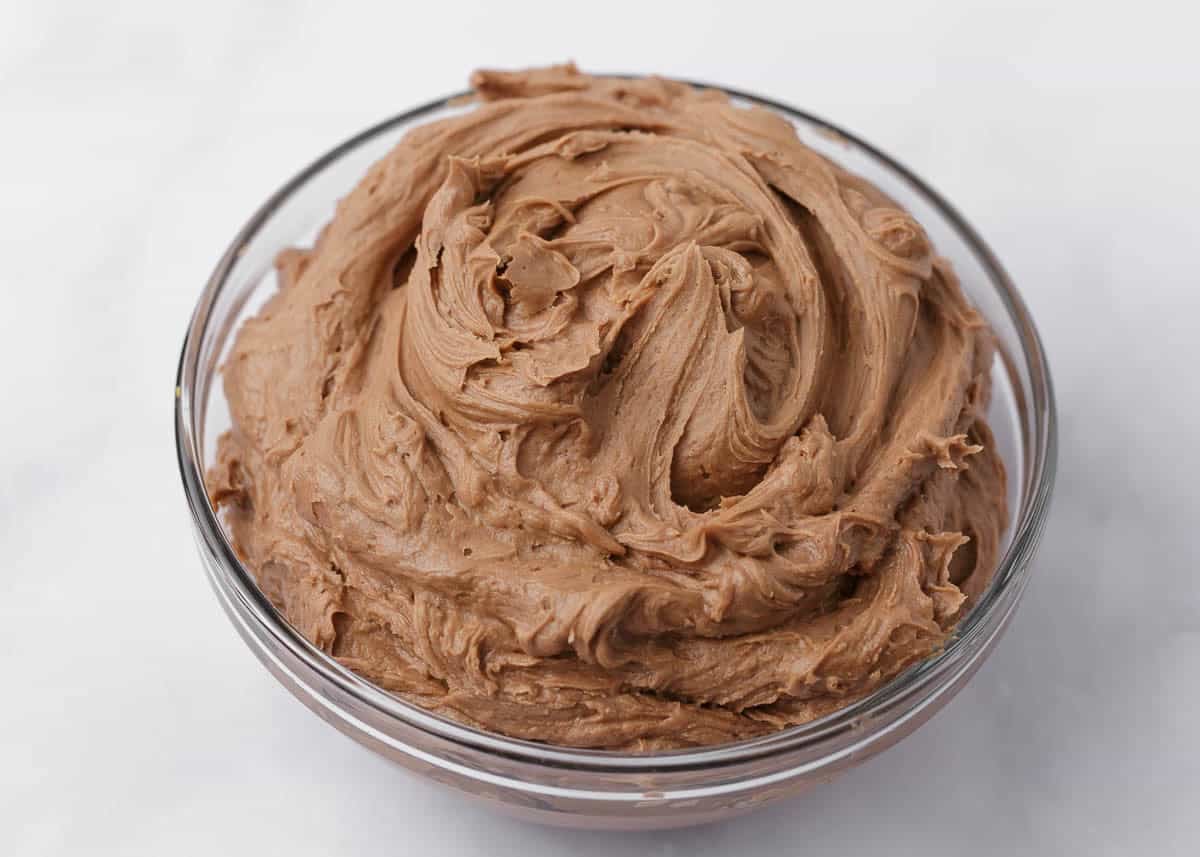 Chocolate buttercream frosting whipped until light and creamy in a mixing bowl.