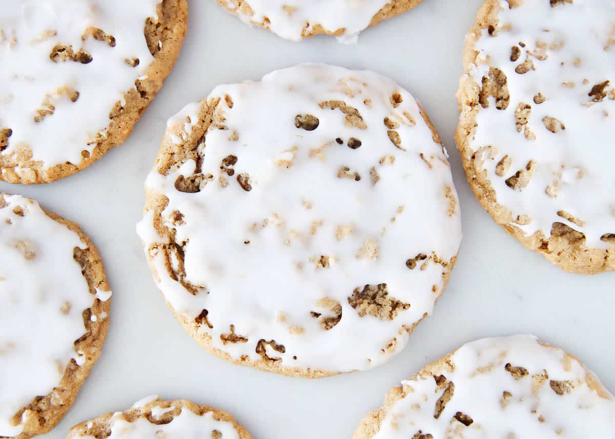 Iced oatmeal cookies on marble counter.