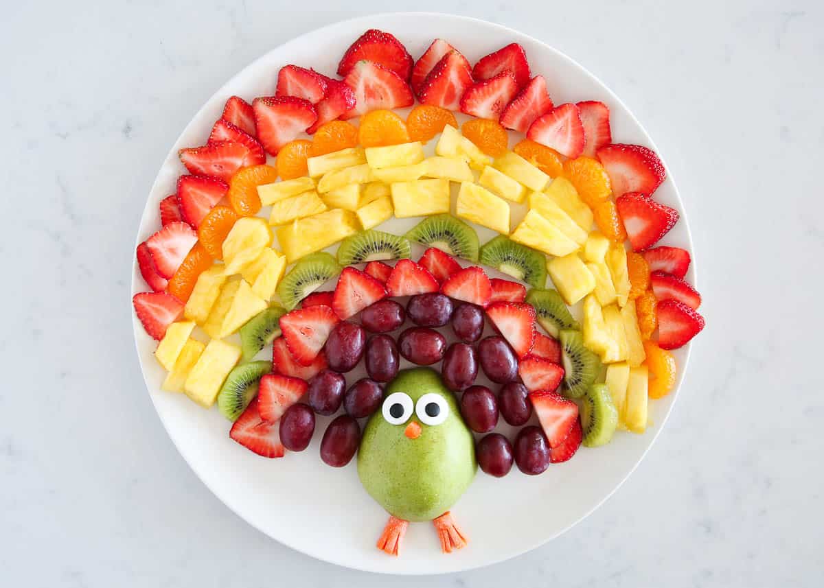 Thanksgiving turkey fruit platter on a white plate.