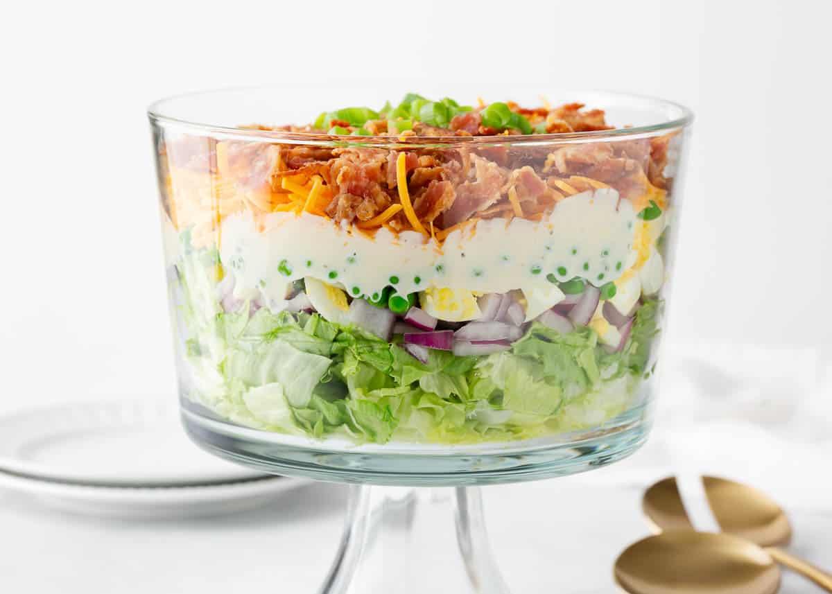 7 layer salad in glass bowl on counter.