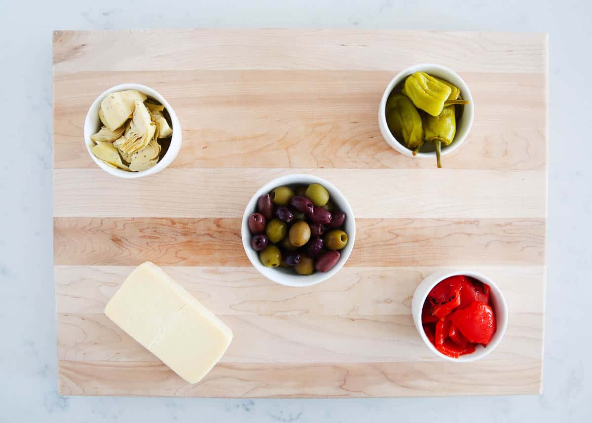 Wooden board with white bowls on top.