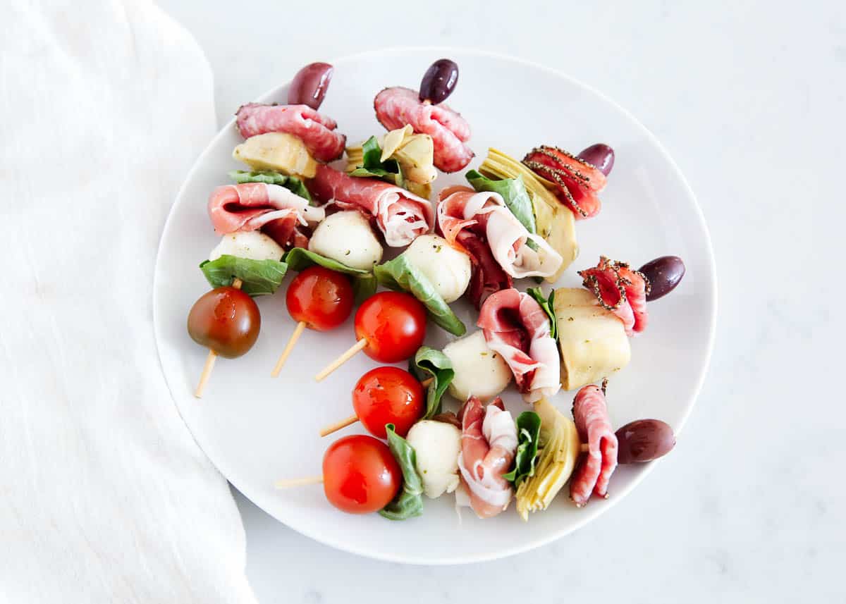 Antipasto skewers on a white plate.