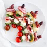Antipasto skewers on a white plate.