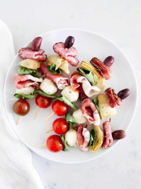 Antipasto skewers on a white plate.