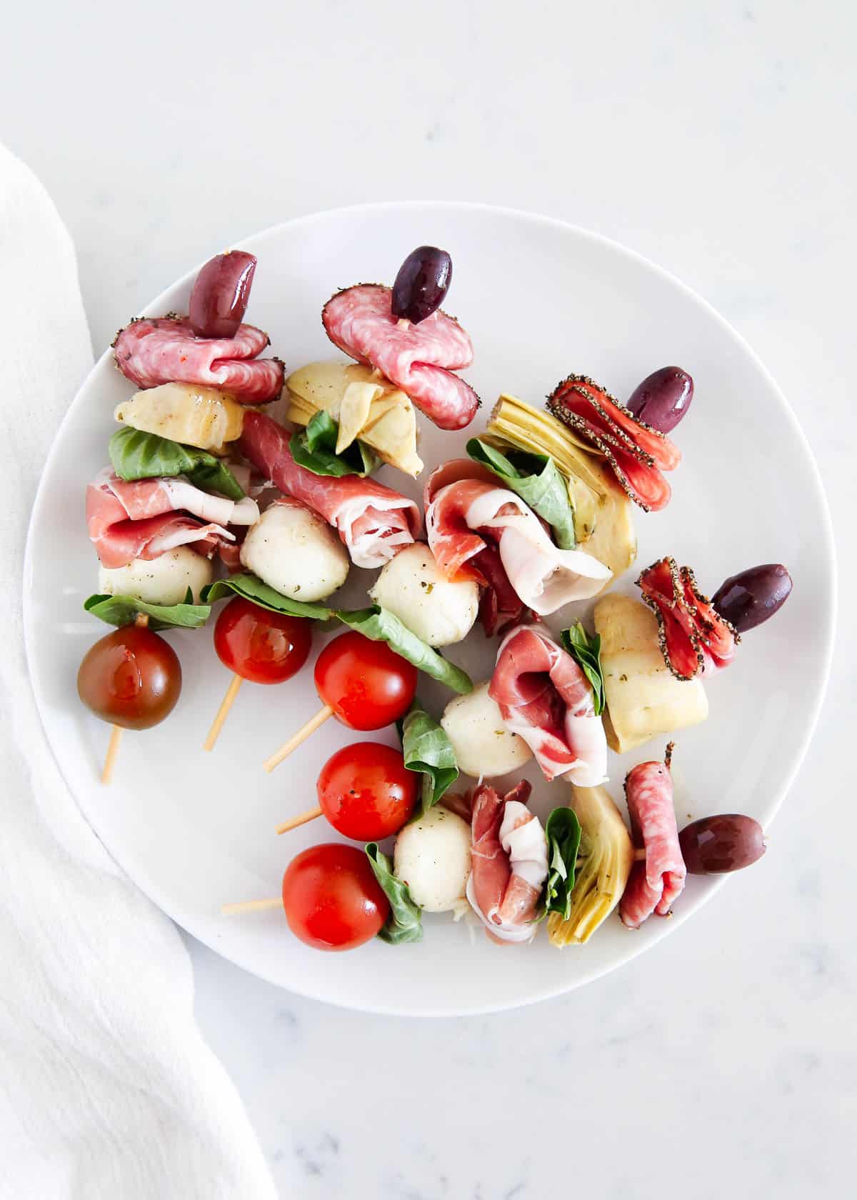 Antipasto skewers on a white plate.