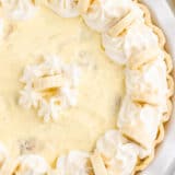 Banana cream pie in white pie dish.
