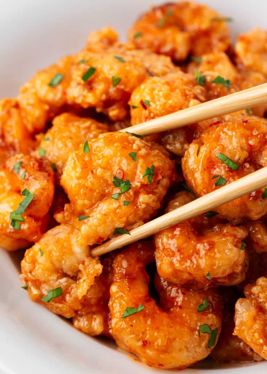 Bang bang shrimp in a white bowl with chopsticks.