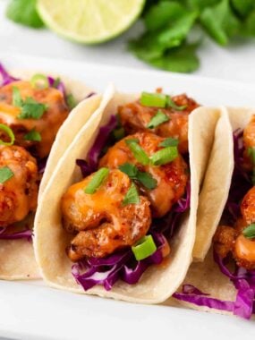 Bang bang shrimp taco on a white platter.