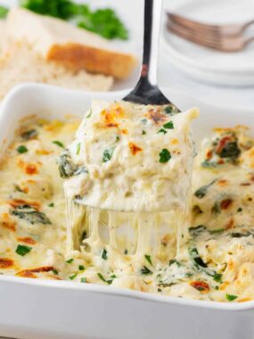 Slice of white chicken lasagna in pan.