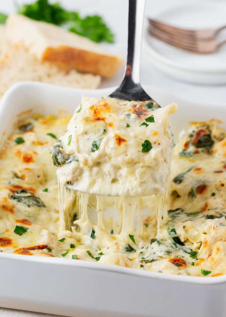 Slice of white chicken lasagna in pan.