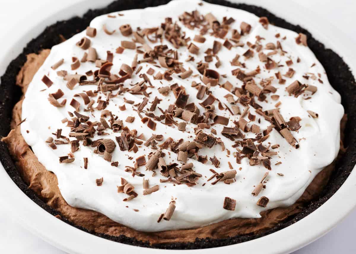 Chocolate silk pie with whipped cream and chocolate shavings on top.