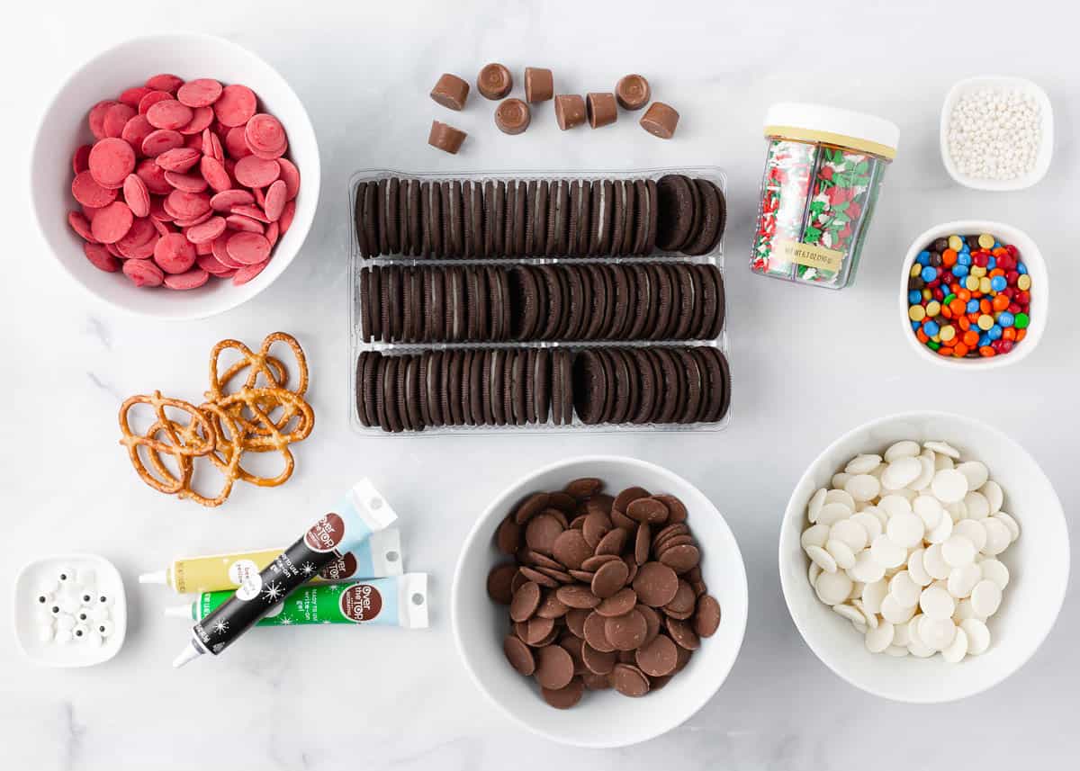 Christmas Oreo ingredients on the counter including Oreo cookies, melting wafers, candy melts, sprinkles and sprinkles.